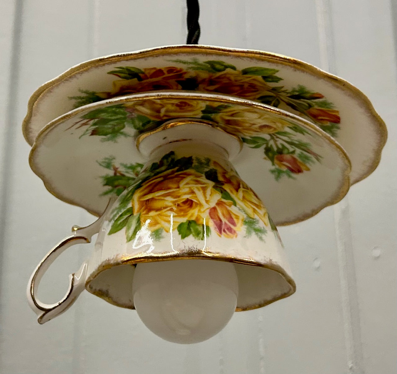 Teacup-shaped lamp with floral design on a white background